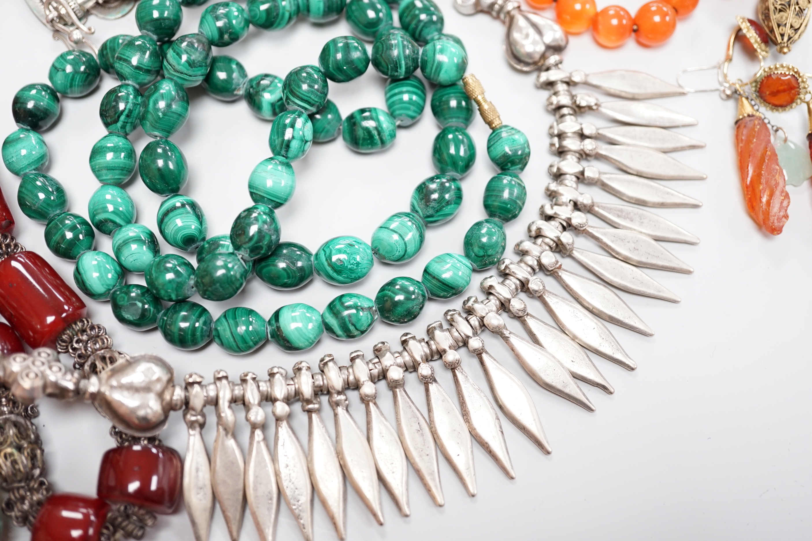 Assorted jewellery including a South American? white metal fringe necklace, a malachite bead necklace, amber earrings, filigree earrings, jet earrings, Hand Of Fatma pendant, agate bead necklace, hardstone pebble necklac